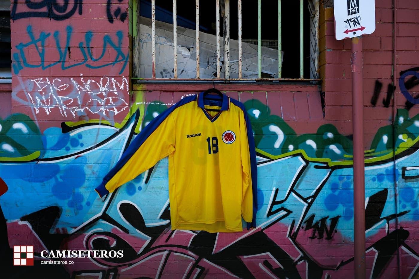 Camiseta amarilla de Colombia, dorsal 19, colgada sobre un muro con grafiti